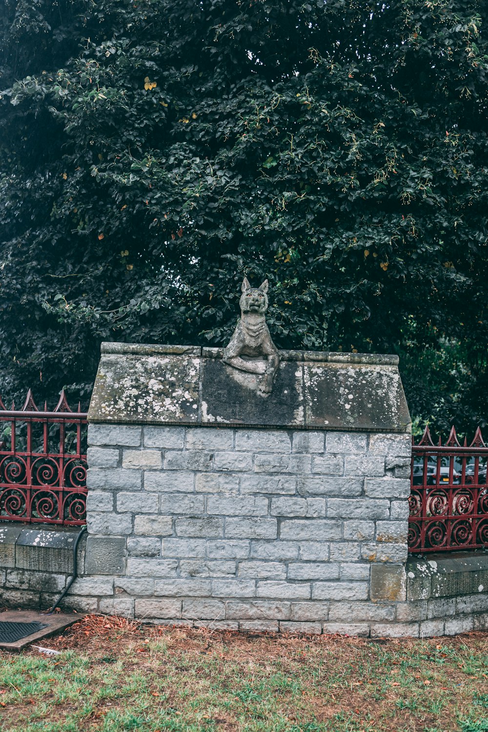 Une statue de pierre sur un mur de briques
