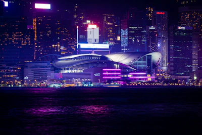 A striking black and purple cityscape at night with glowing neon signs.