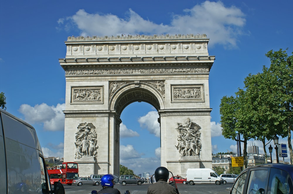 a large stone monument with Arc de Triomphe in the background