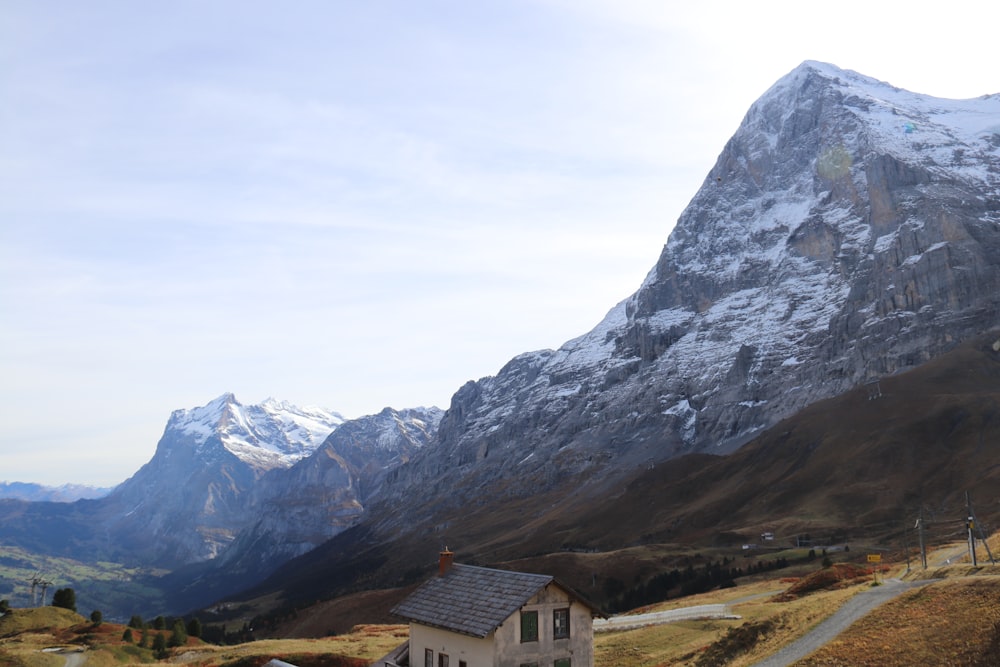 a small house in front of a mountain range