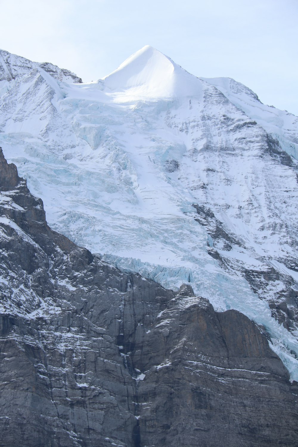 a snowy mountain with a large rock wall