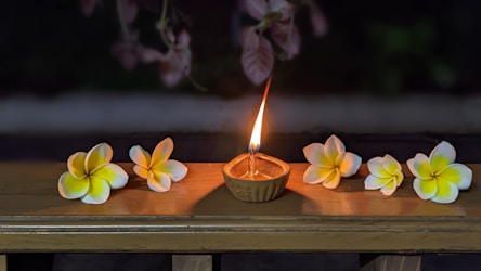 a candle in a bowl with flowers