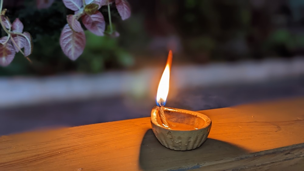 a candle burning in a bowl