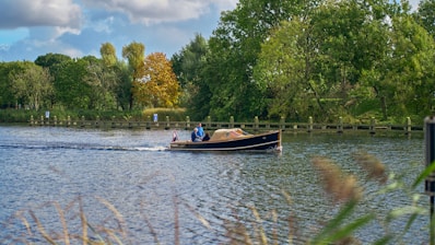 A couple enjoying a serene boat ride on a calm river surrounded by lush greenery