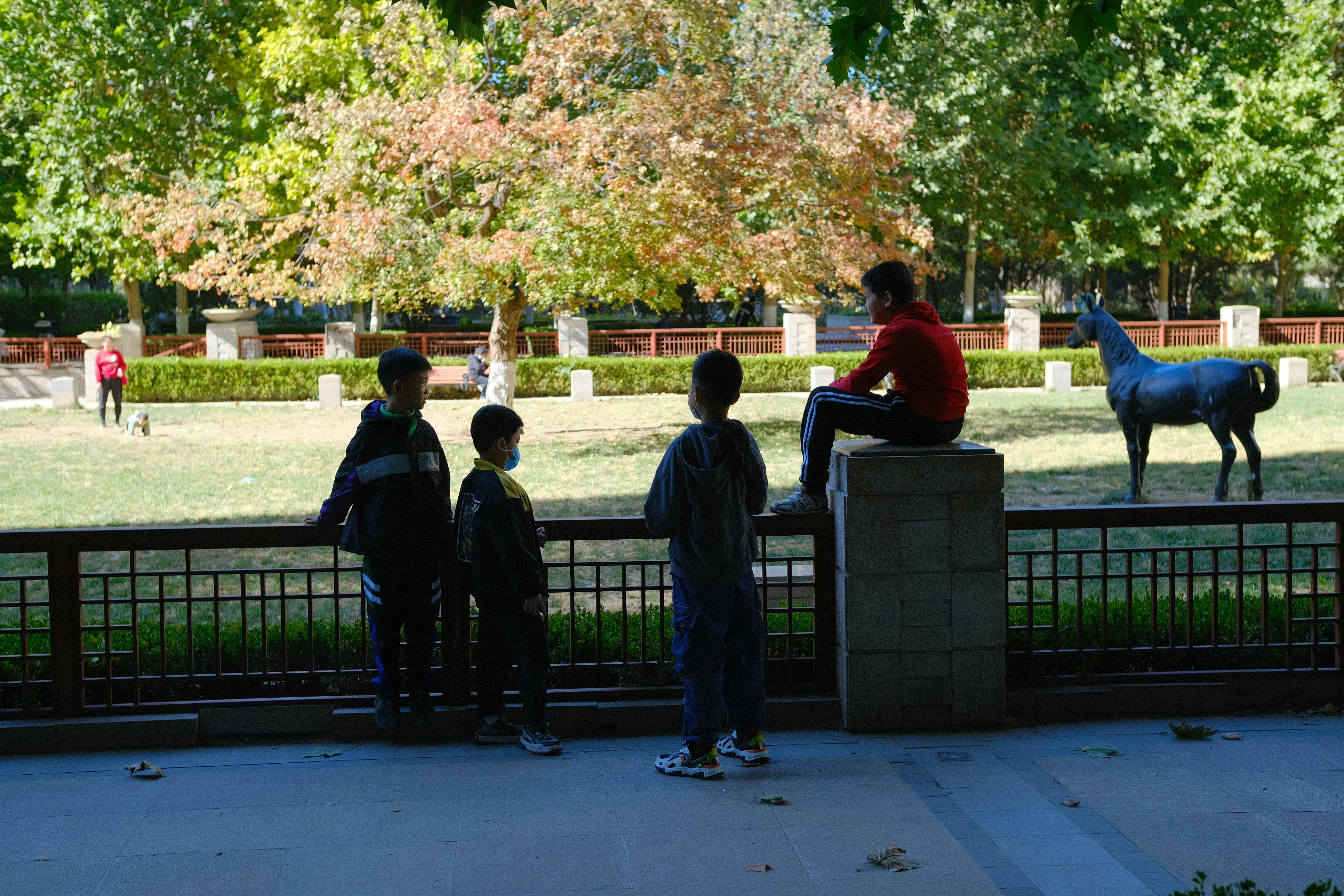 A group of concerned parents discussing outside a school, or a teacher looking thoughtful while grading papers, symbolizing the collective responsibility.