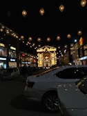 Evening view of a lively shopping center illuminated by warm lights and busy with visitors.