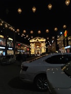 Evening shot of a shopping center glowing with warm lights and inviting storefronts.