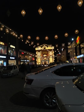 Evening shot of a shopping center glowing with warm lights and inviting storefronts.