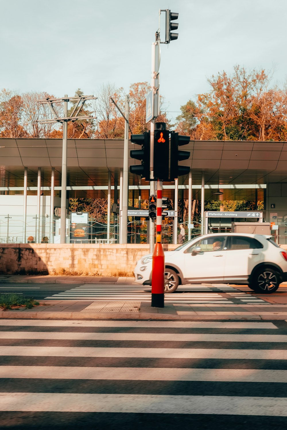 a white car is parked at a traffic light