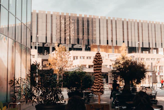 Urban plastic furniture surrounded by green plants and recyclable materials in an industrial setting.