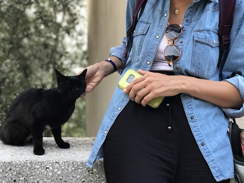 a person holding a bottle and a cat