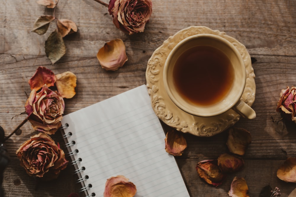 a cup of coffee and some seashells on a table