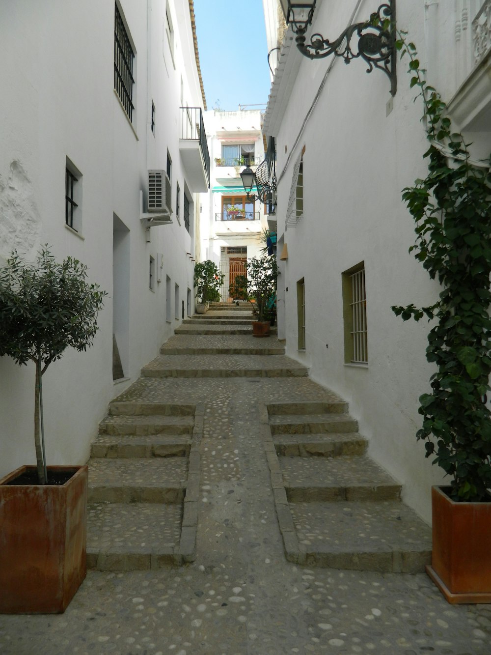 a stone walkway between white buildings