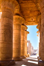 Artistic column-shaped cat scratcher modeled after Karnak temple pillars in warm papyrus cream tones.