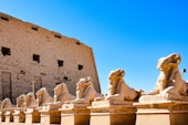 a group of statues in front of a stone building