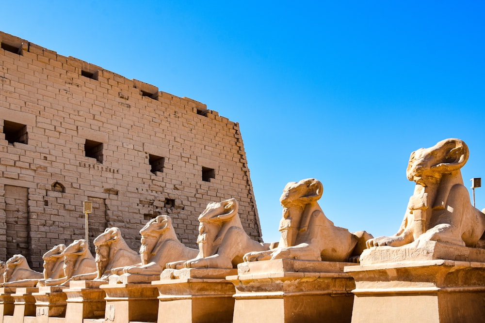 a group of statues in front of a stone building