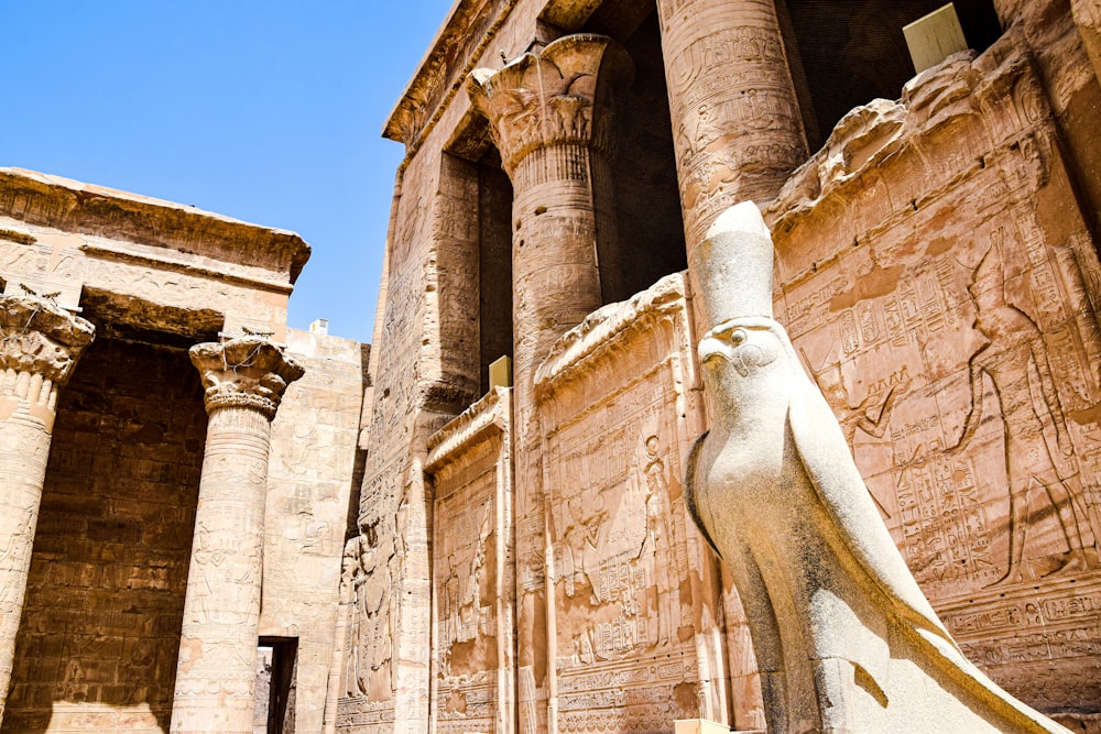 a stone building with a statue in front of it