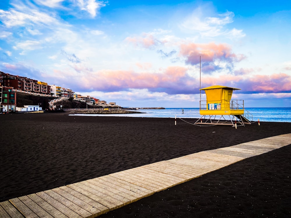 a yellow structure on a beach