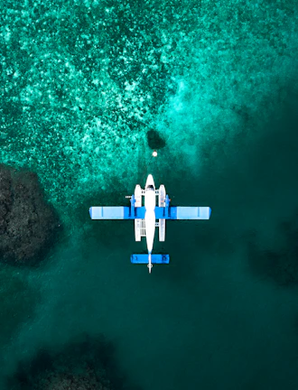 Private seaplane flying over the crystal-clear waters of the Riviera Maya coastline.