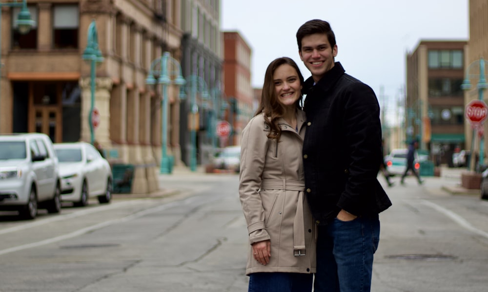 a man and woman posing for a picture on a street