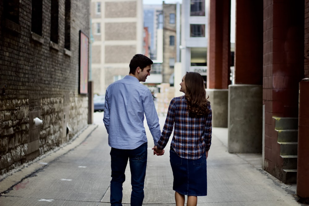 a man and woman walking down a sidewalk