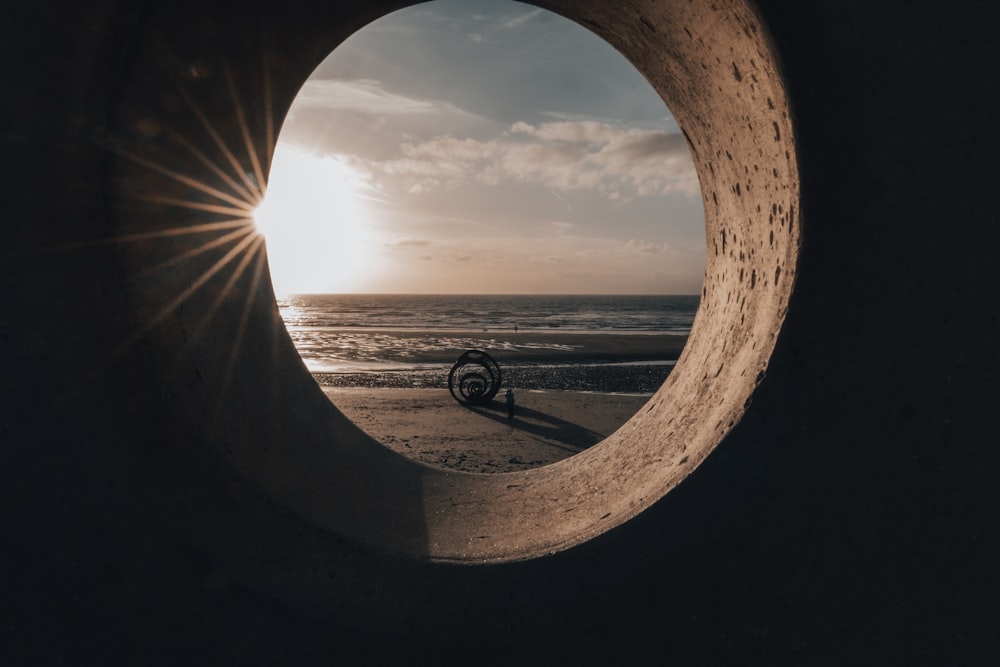 a view of the ocean through a hole in a stone wall