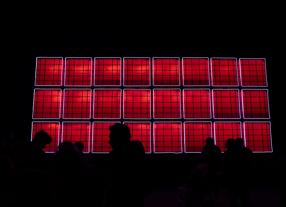 a group of people looking at a large window with red and blue lights