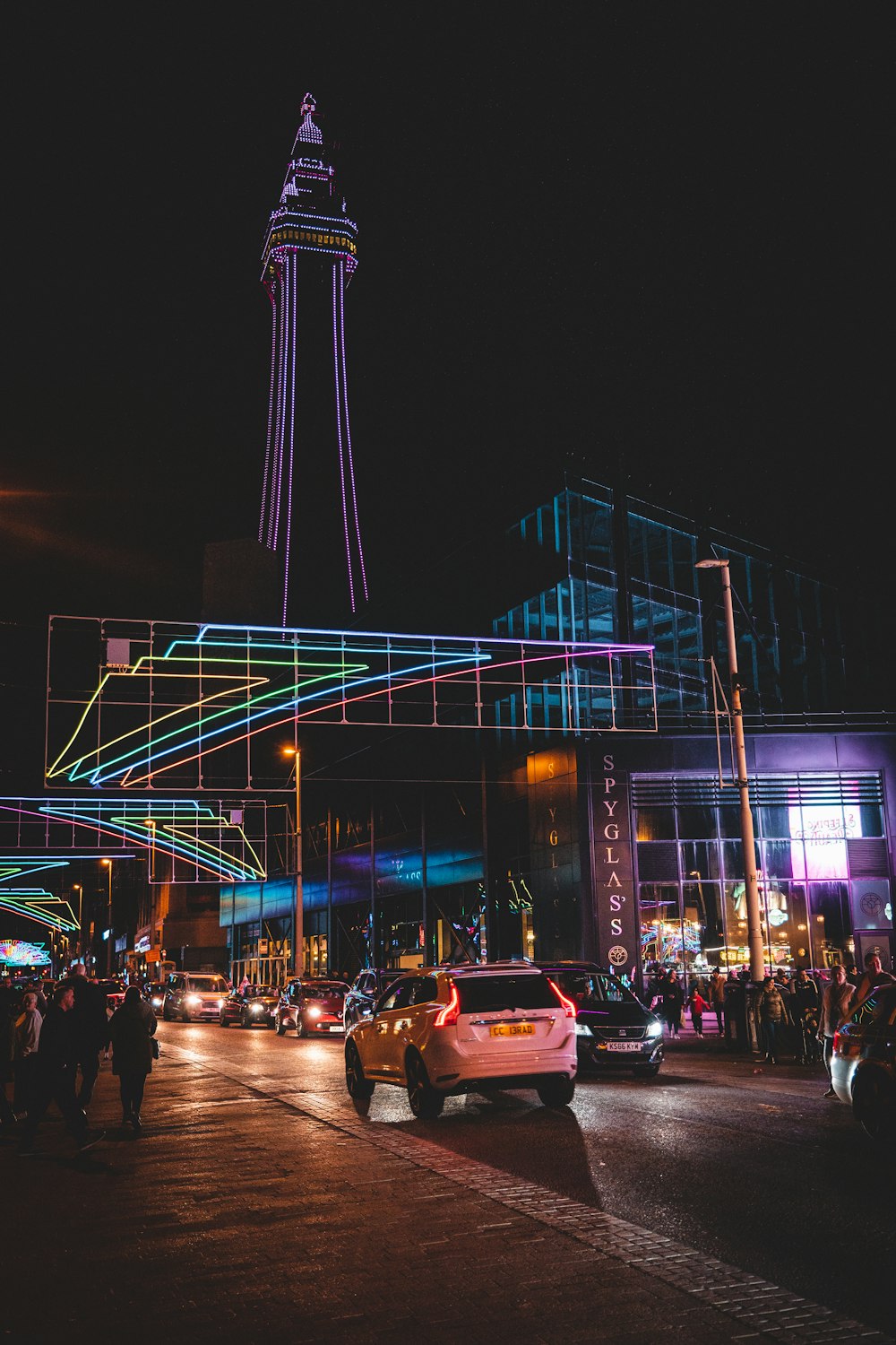 a street with cars and buildings with lights