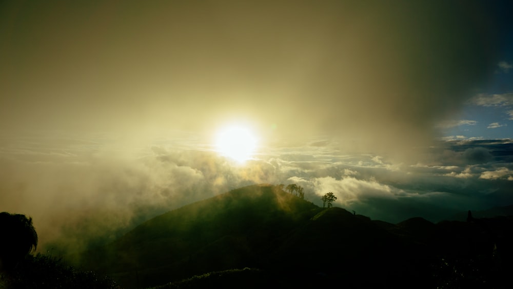 a hill with the sun in the background