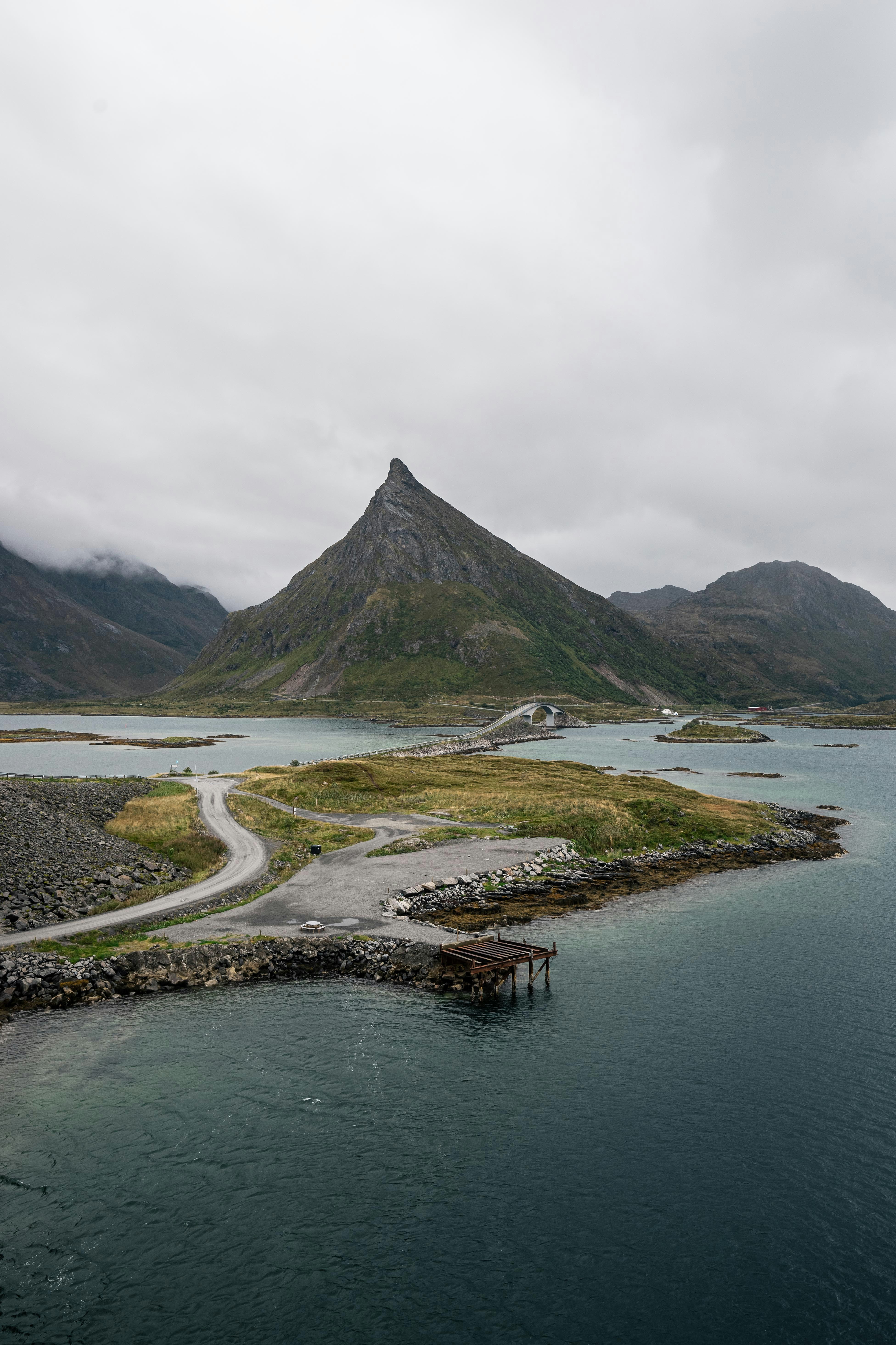 Bridge by Fredvang, Norway leading up to iconic triangular mountain