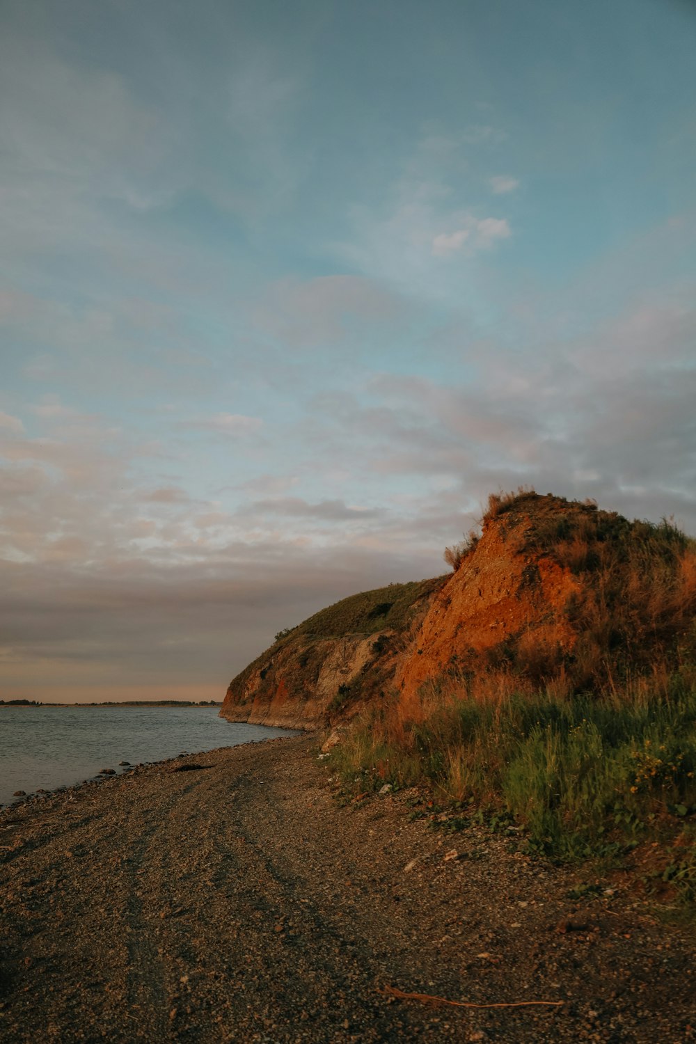 a beach with a hill and water