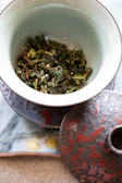 Artful arrangement of tea leaves and dried flowers in a ceramic bowl.