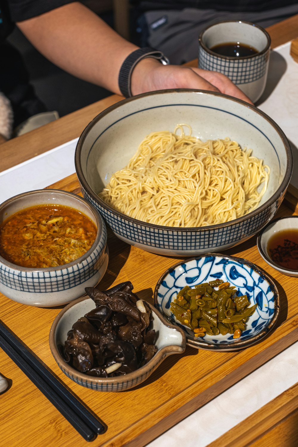 a table with bowls of food and a person sitting at a table