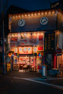 A vibrant storefront featuring bold LED signboards glowing warmly at dusk.