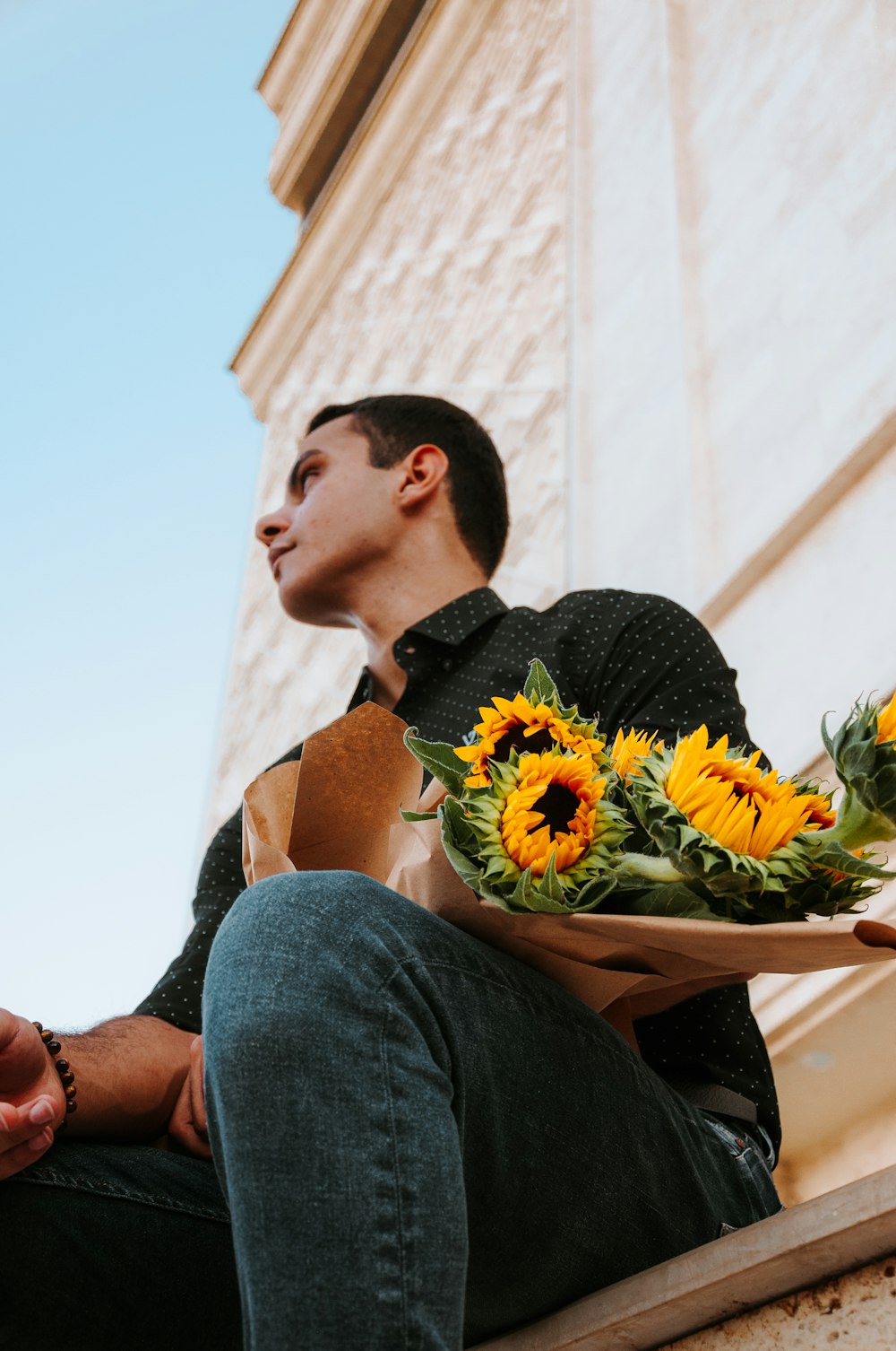 a person sitting on a bench with a bouquet of flowers