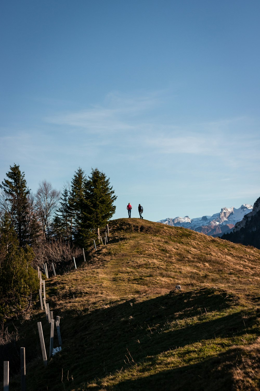 two people walking on a hill