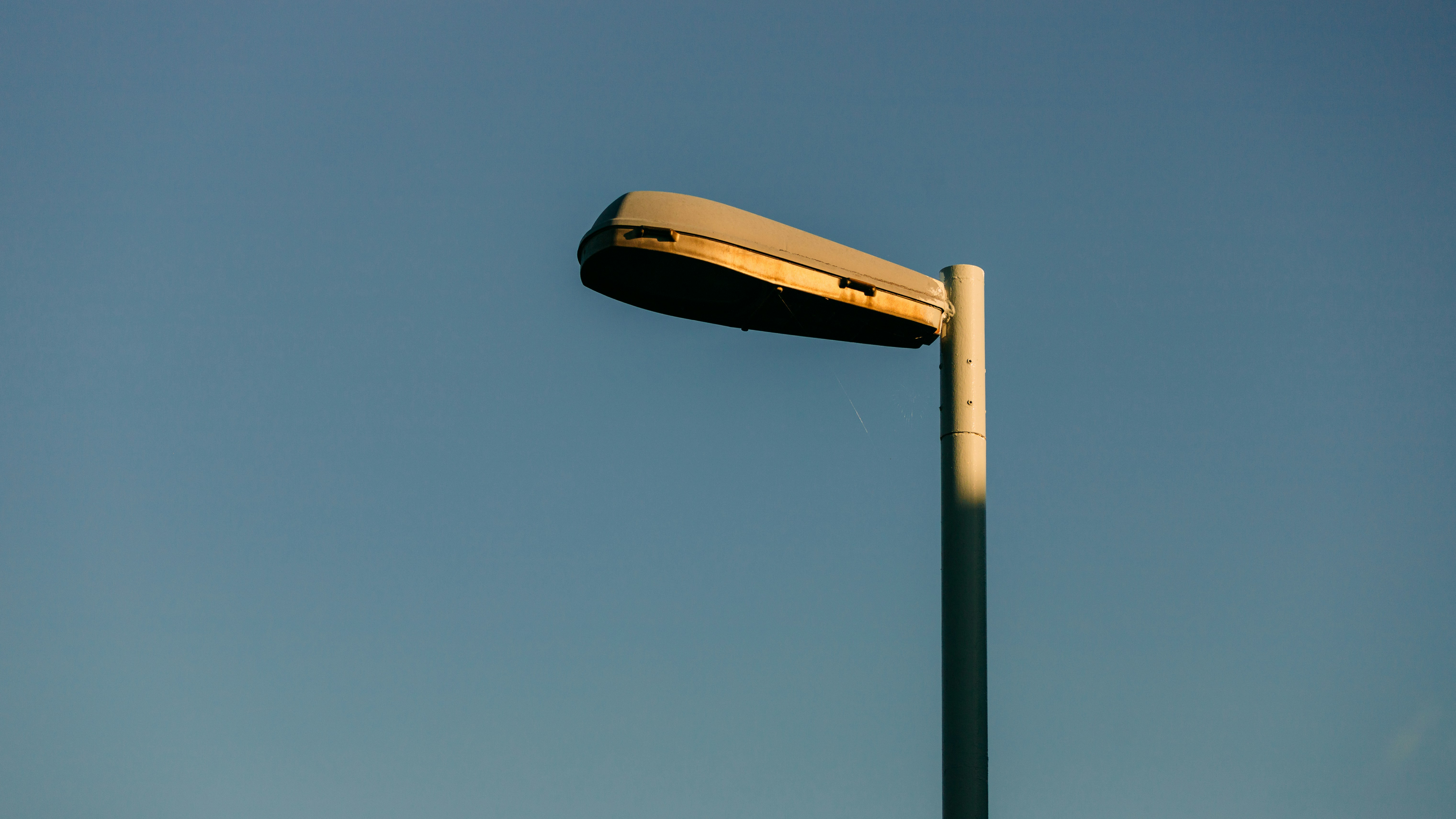 A light post with a yellow object on top photo Free Street