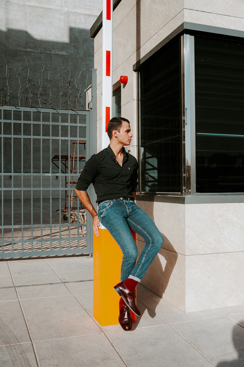 a person sitting on a yellow post