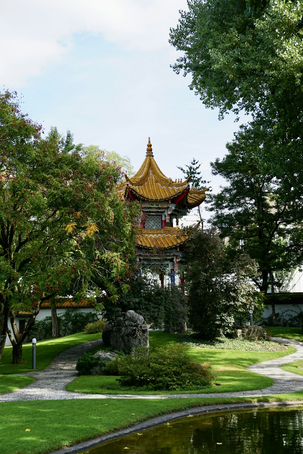 Una pagoda con un estanque frente a ella