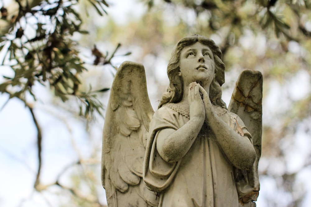 une statue d’une personne tenant une croix