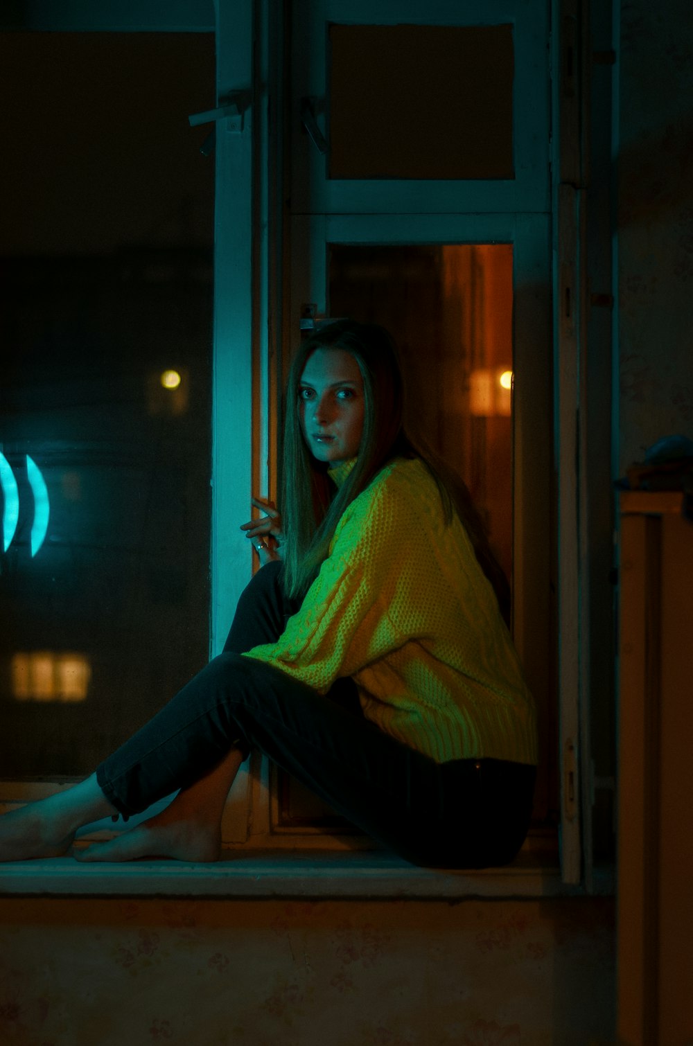 a person sitting on a window sill