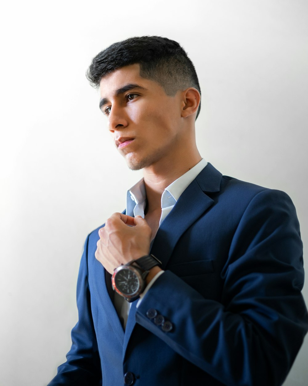 a man wearing a suit and holding a watch