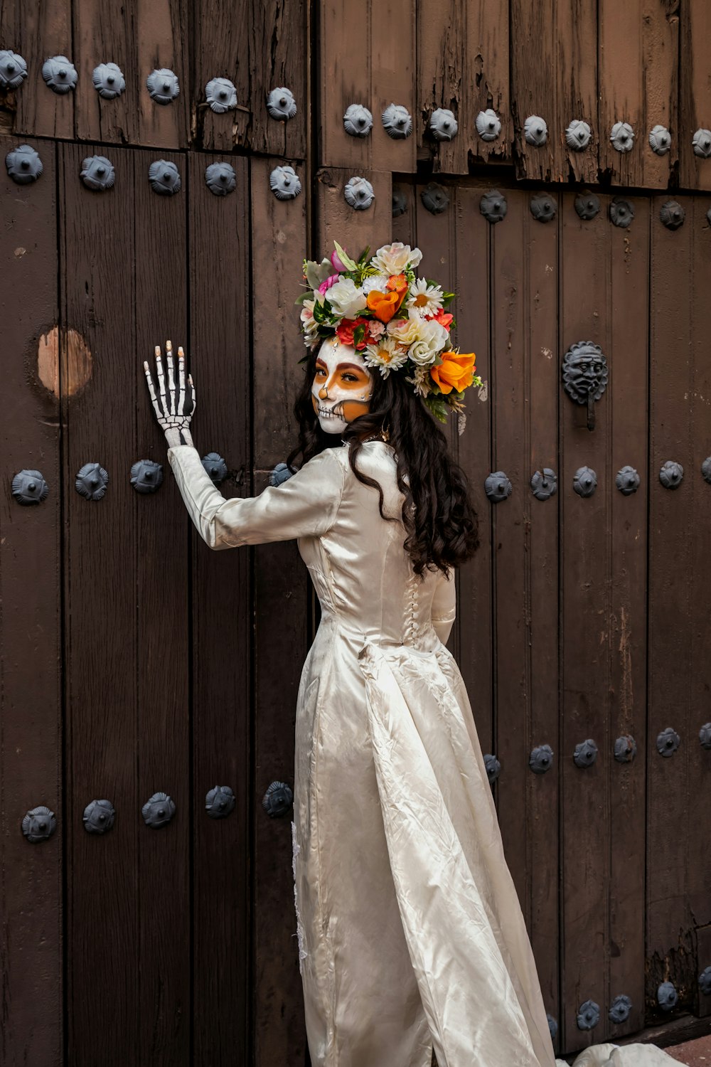 a person in a white dress holding a sword and a crown