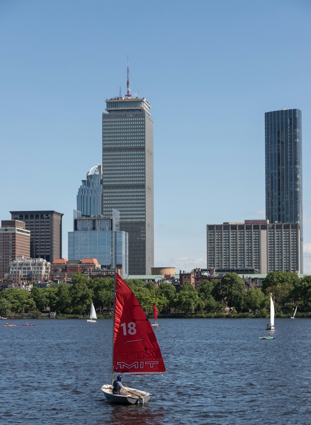a group of sailboats on the water with Prudential Tower in the background