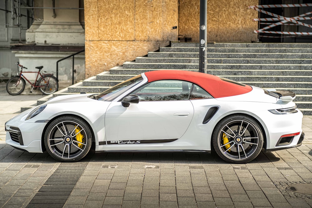 a white sports car parked on a brick road