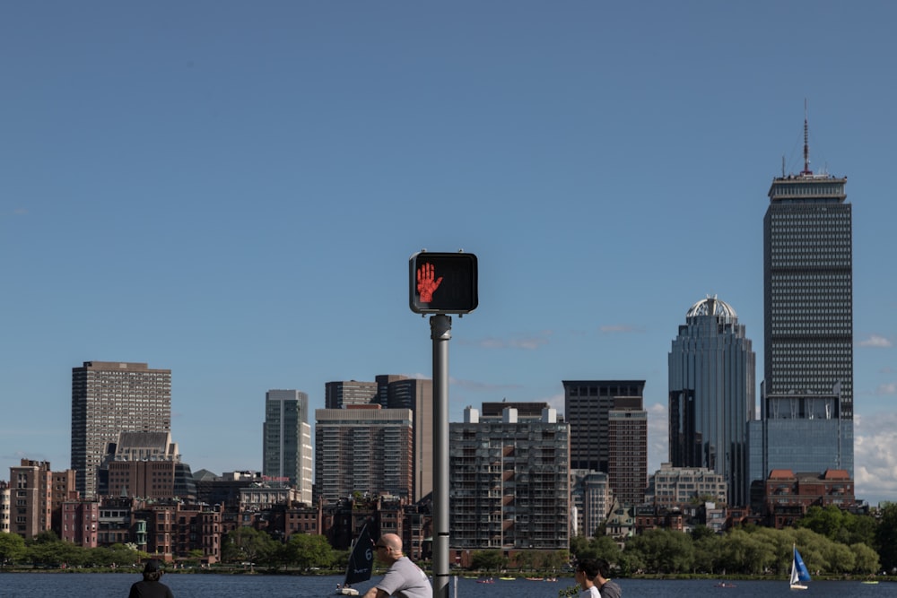 a clock on a pole in front of a city