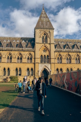 a person standing in front of a building with many arches and windows