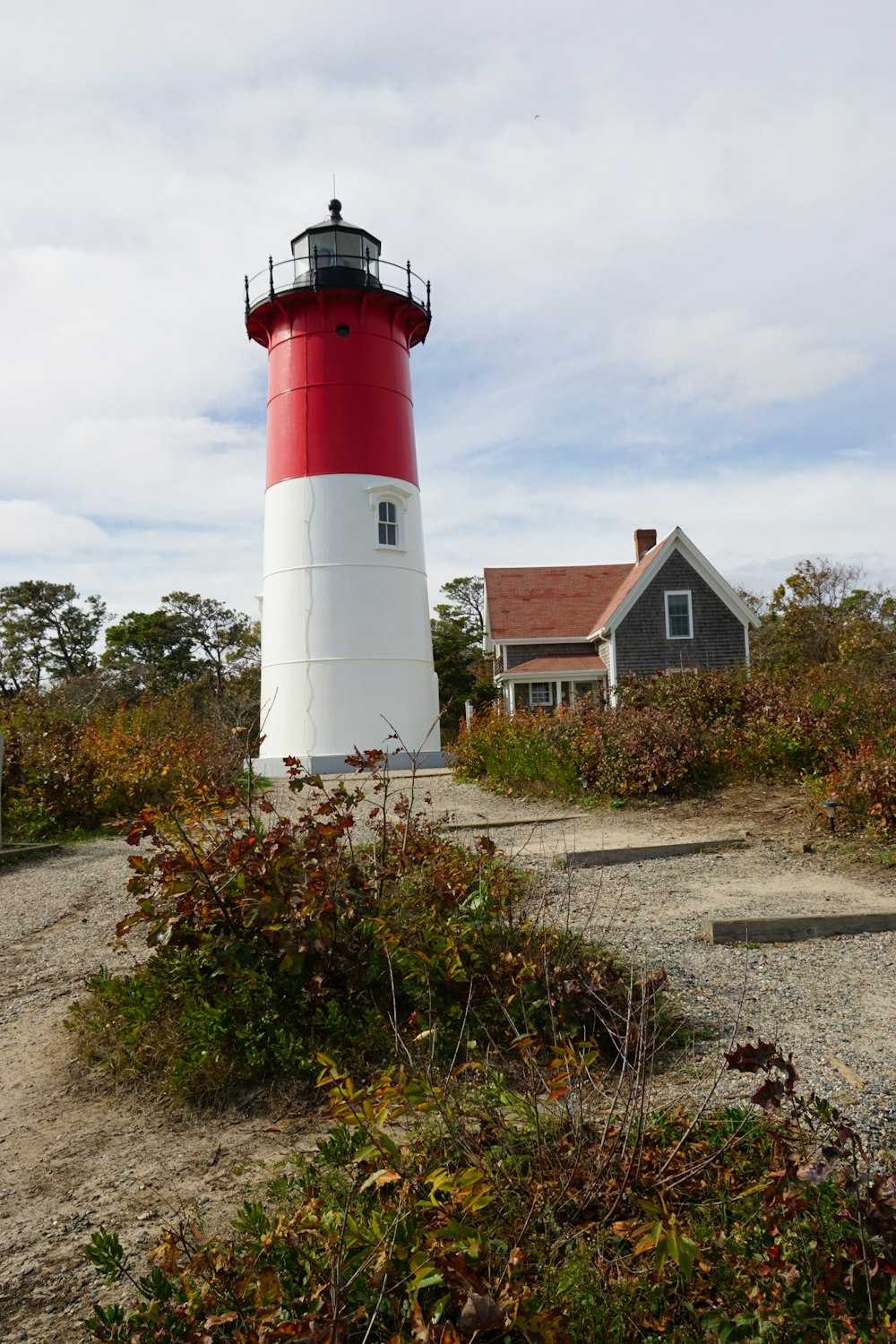 a lighthouse with a red and white top with Nauset Light in the background