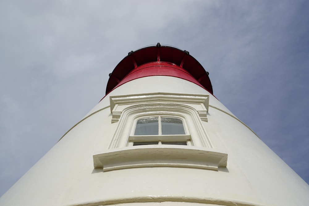 una torre blanca con una tapa roja