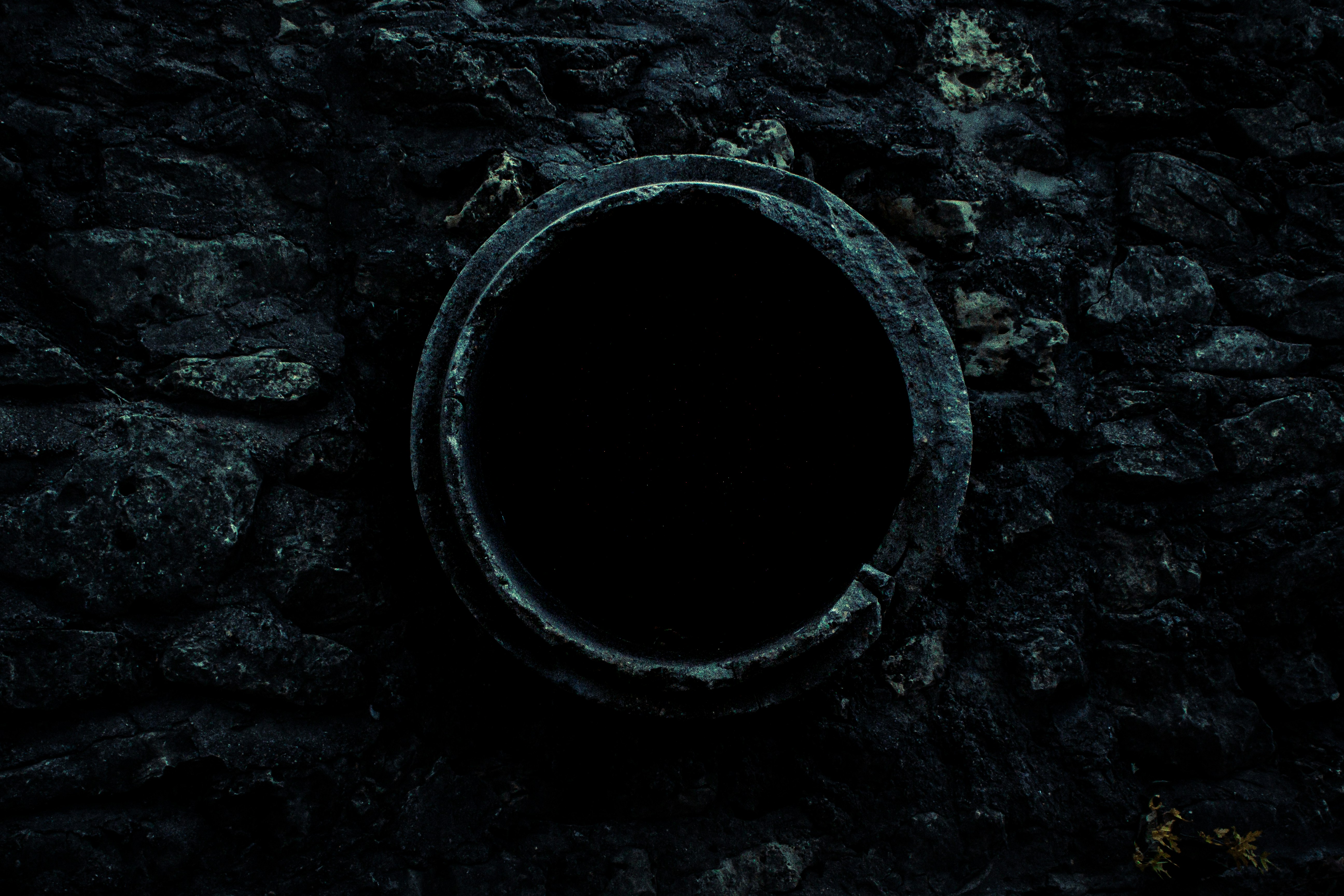 a round black object on a rocky surface